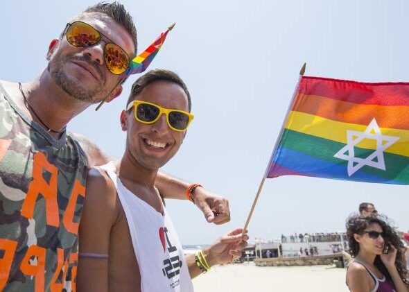 Members of the LGBTQ community in Israel holding pride flag with a star of david