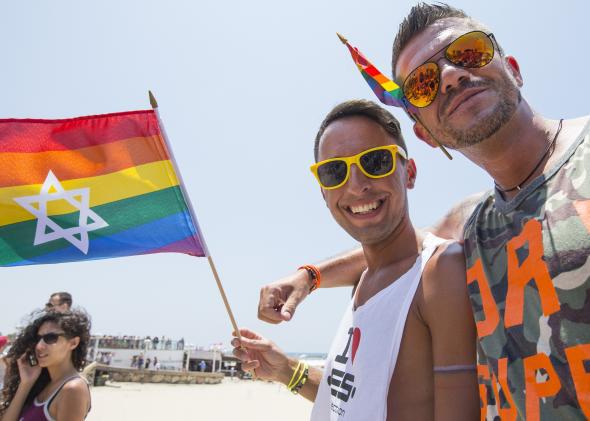Members of the LGBTQ community in Israel holding pride flag with a star of david